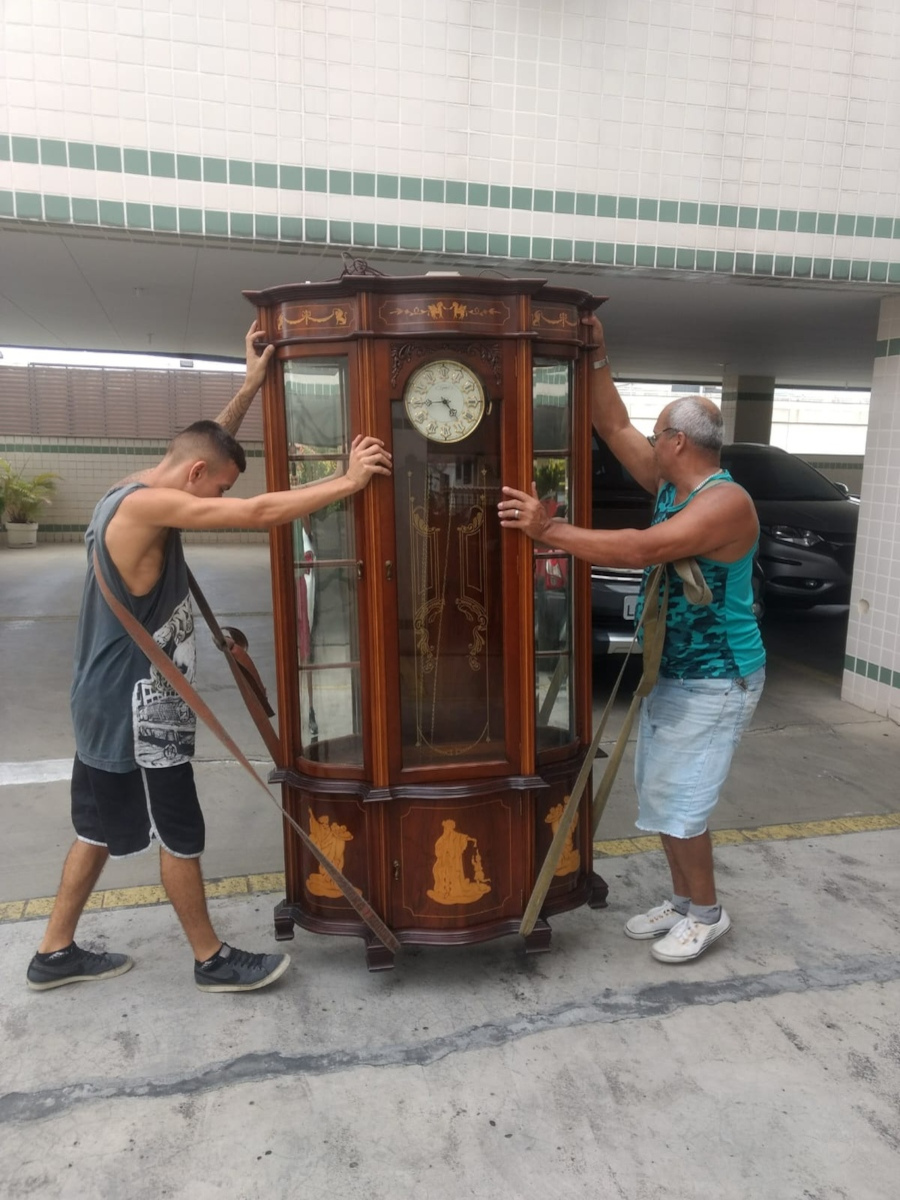 foto mostrando dois funcionários carregando um carrilhão